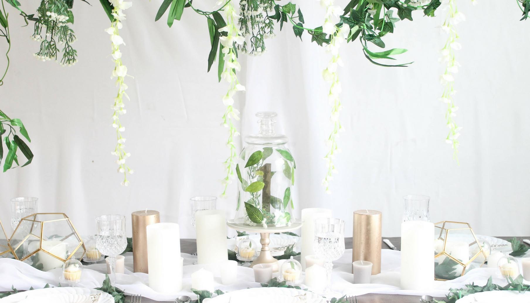 Reception table setting details - Black tablecloth, white candles, black  birdcage with white and green floral arrangement