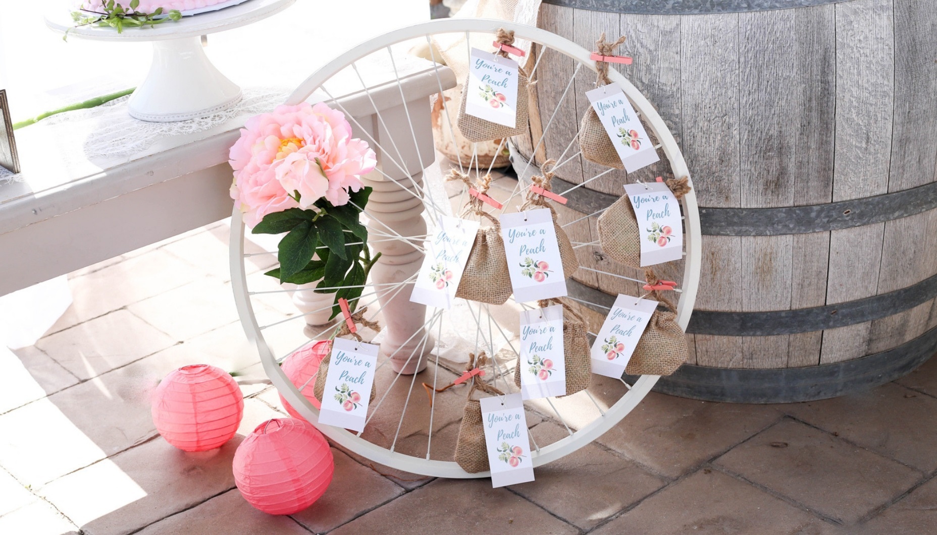 Bike wheel party decor to diplay peach themed favors