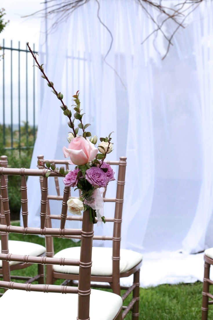 Rose gold chiavari chairs and wildflower adorned aisle for the bride to walk down at this Wildflower Fields wedding.