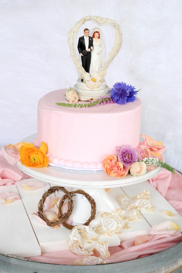 Wildflower adorned wedding cake with vintage topper. Loads of wedding inspiration in this anthro style floral wedding.