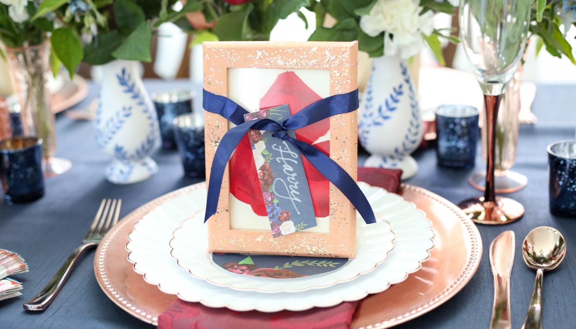 Pressed rose petals under glass for a navy and marsala wedding palette