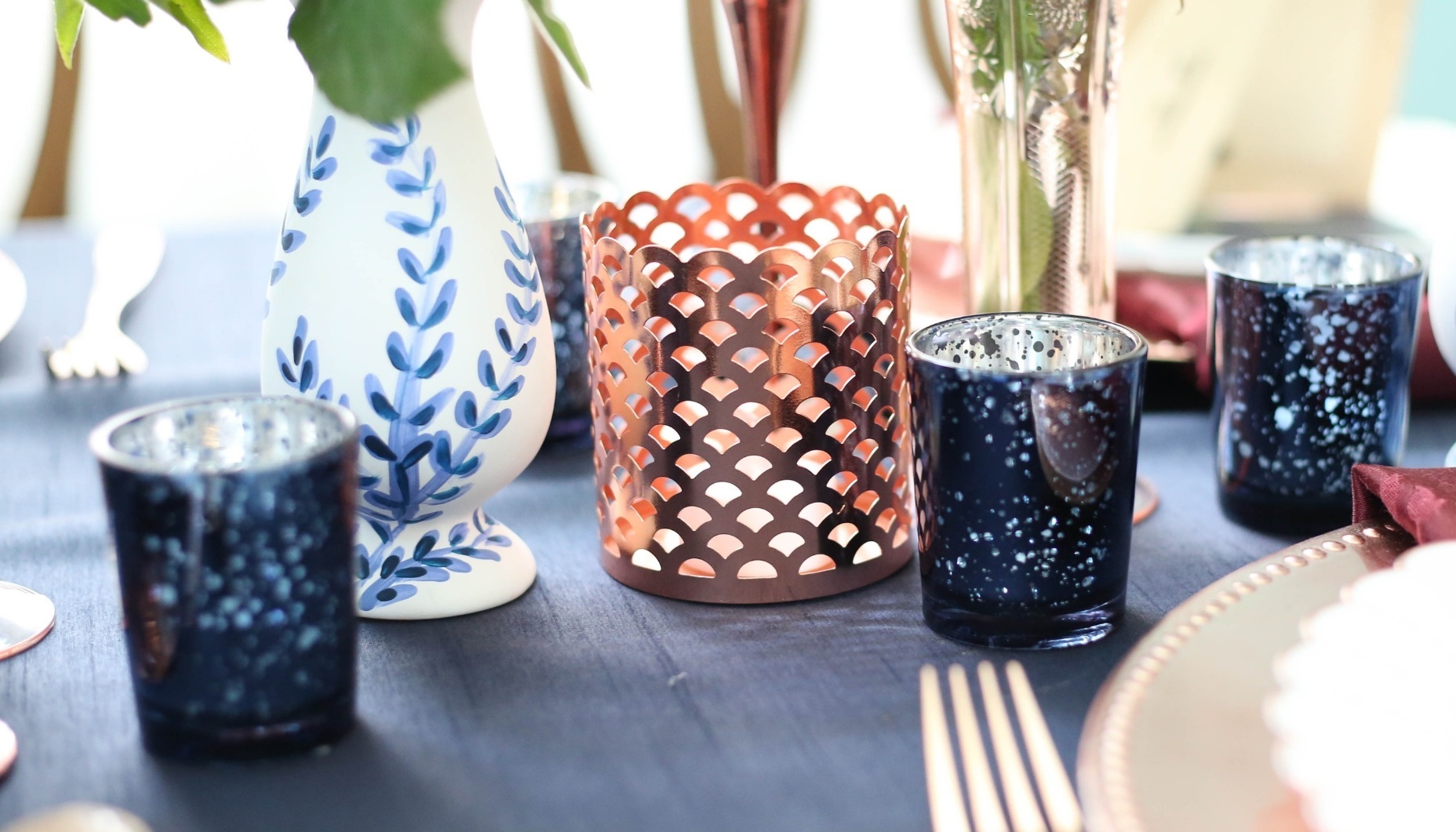 votive holders in rose gold and navy for a wedding table design