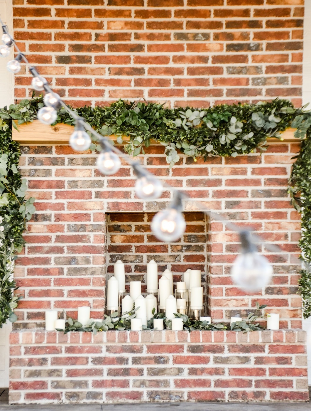 fall farmhouse wedding decorated brick fireplace with candles and greenery garlands by Kara's Party Ideas