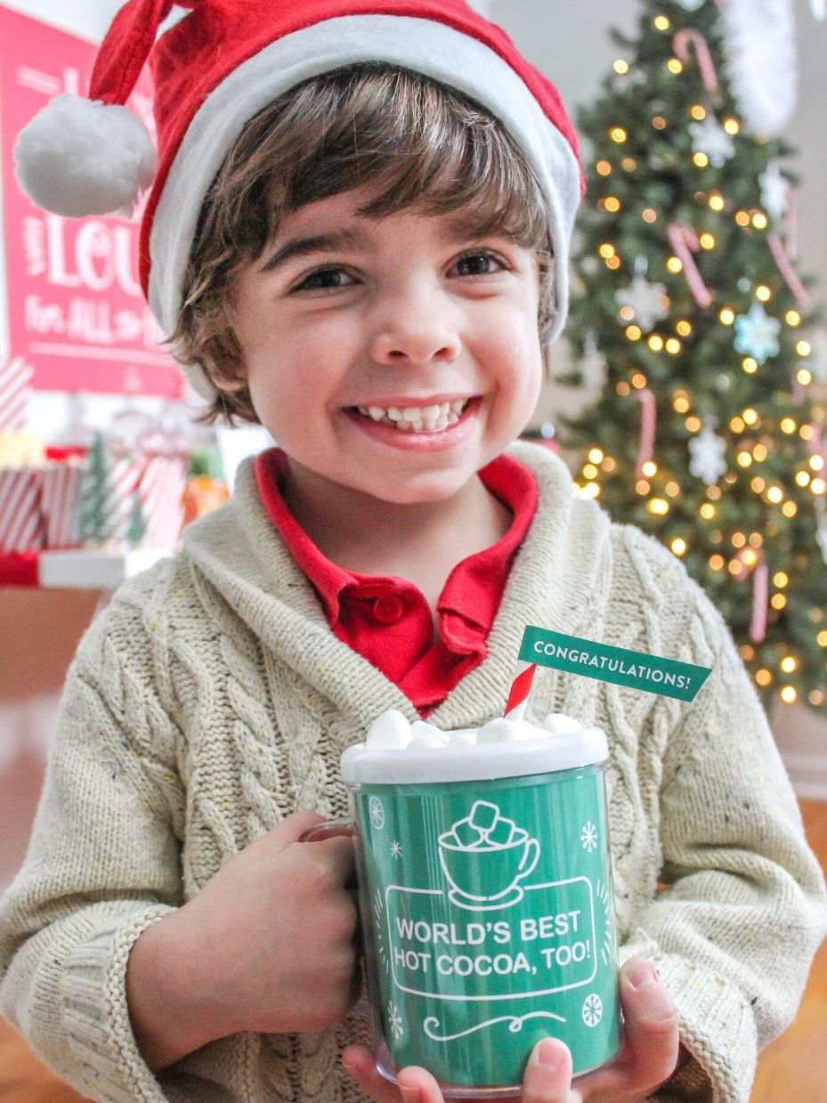 Boy holding World's Best Hot Cocoa mug