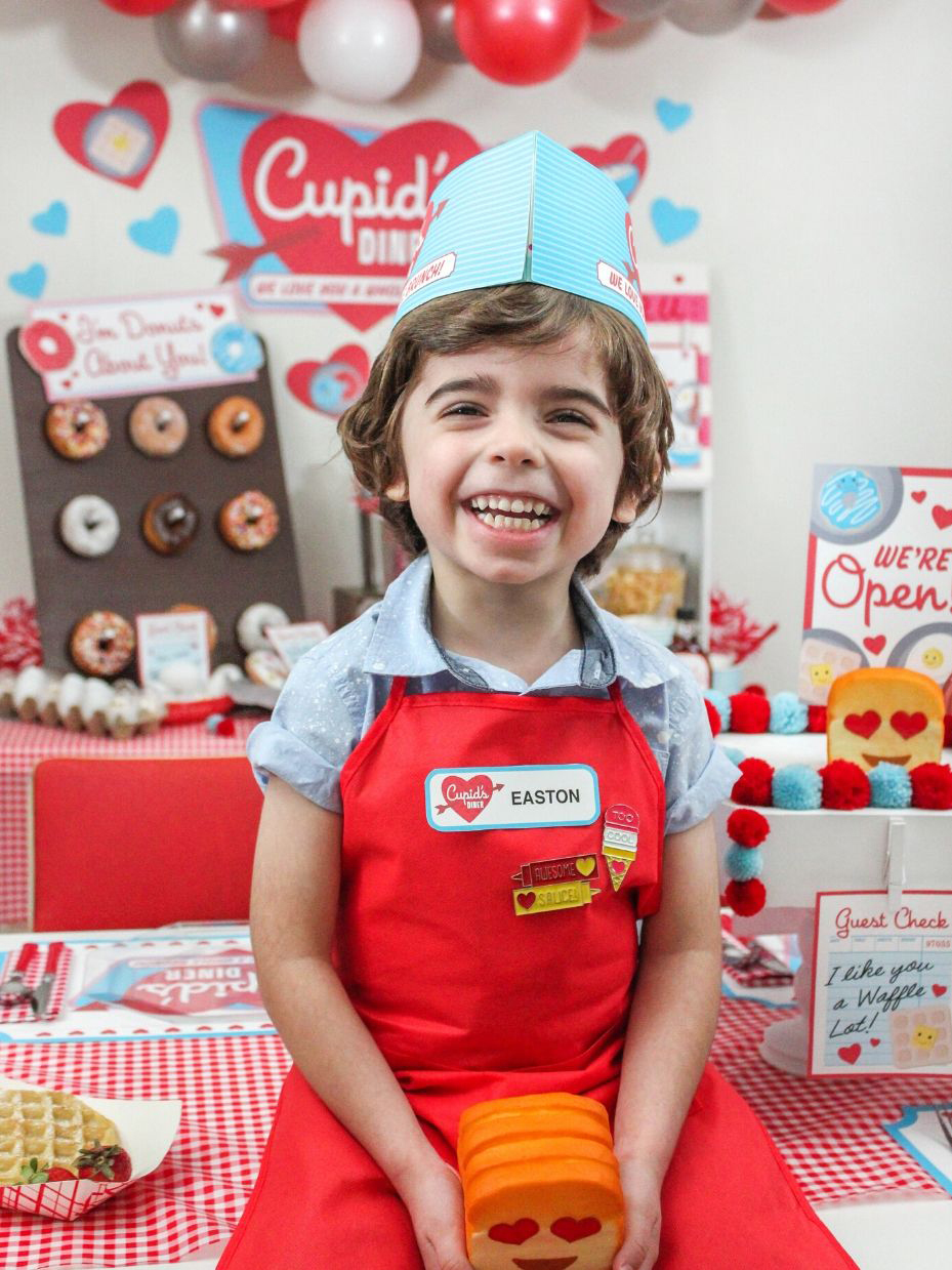 boy dressed like a diner waiter holding a toast squishie