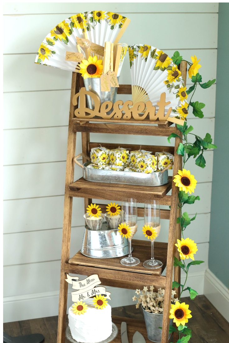 Ladder shelf dessert display with sunflower themed favors and desserts