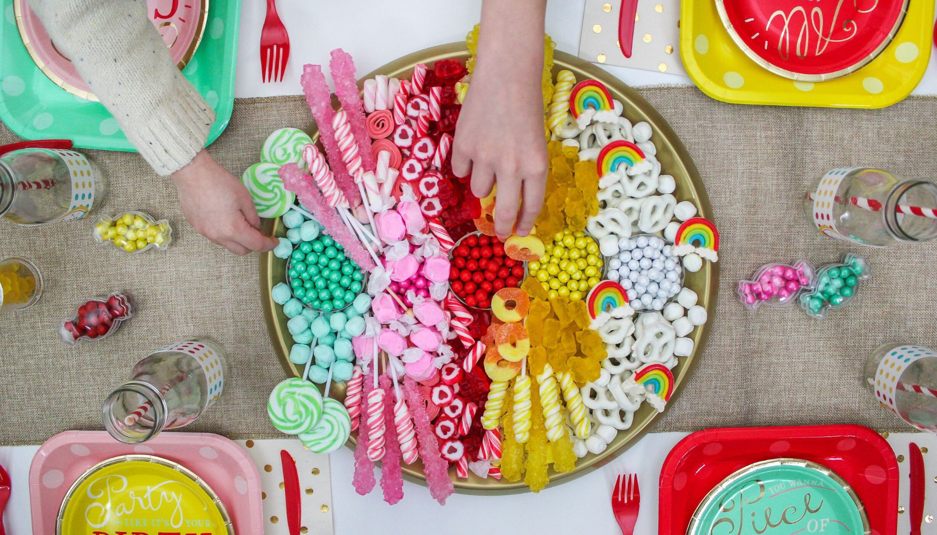 top down view of candy board with kids hands picking candy
