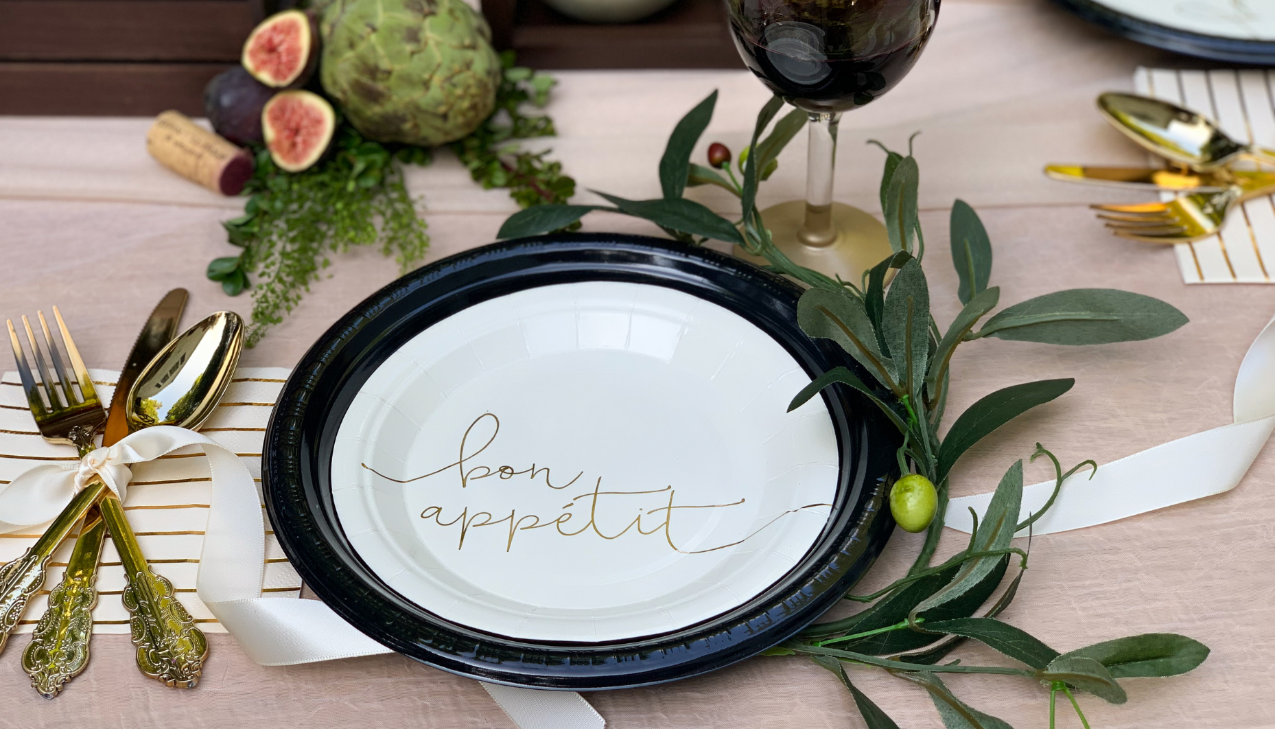 Olive branches and simple tableware with gold accents create a warm and inviting tablescape for an Italian Bridal Shower.